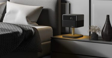 Epson Lifestudio Flex EF-73 Night Black posé sur table de nuit avec éclairage LED ambiance dorée