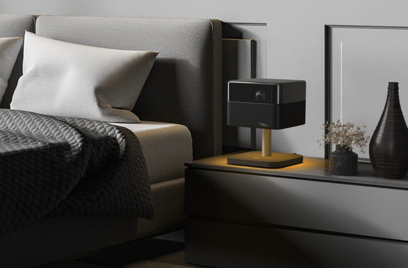 Epson Lifestudio Flex EF-73 Night Black posé sur table de nuit avec éclairage LED ambiance dorée