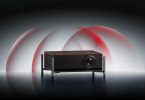 Vidéoprojecteur Xgimi Titan 4K noir sur support minimaliste avec ondes lumineuses rouges symbolisant la technologie double laser et les certifications IMAX Enhanced et Dolby Vision.
