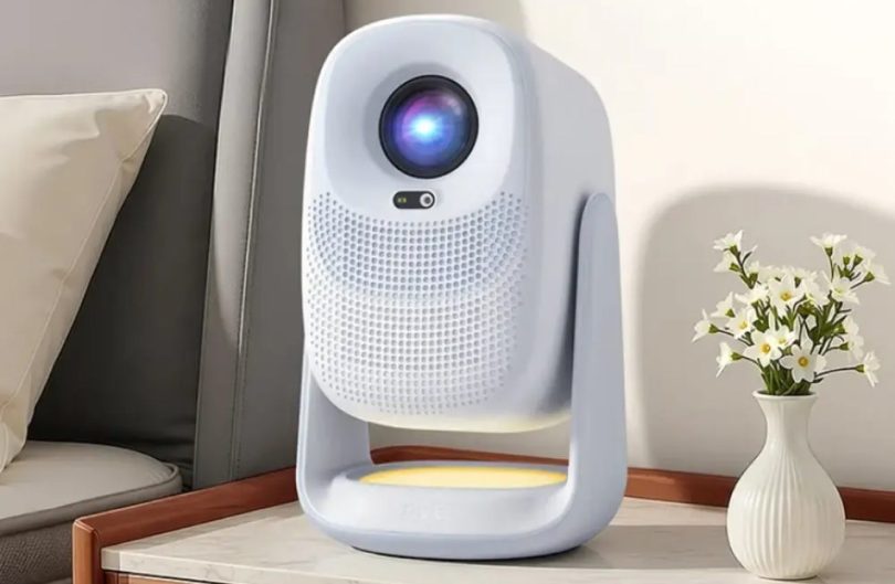 Vidéoprojecteur OBE C3 Max blanc sur support cardan intégré posé sur une table de salon