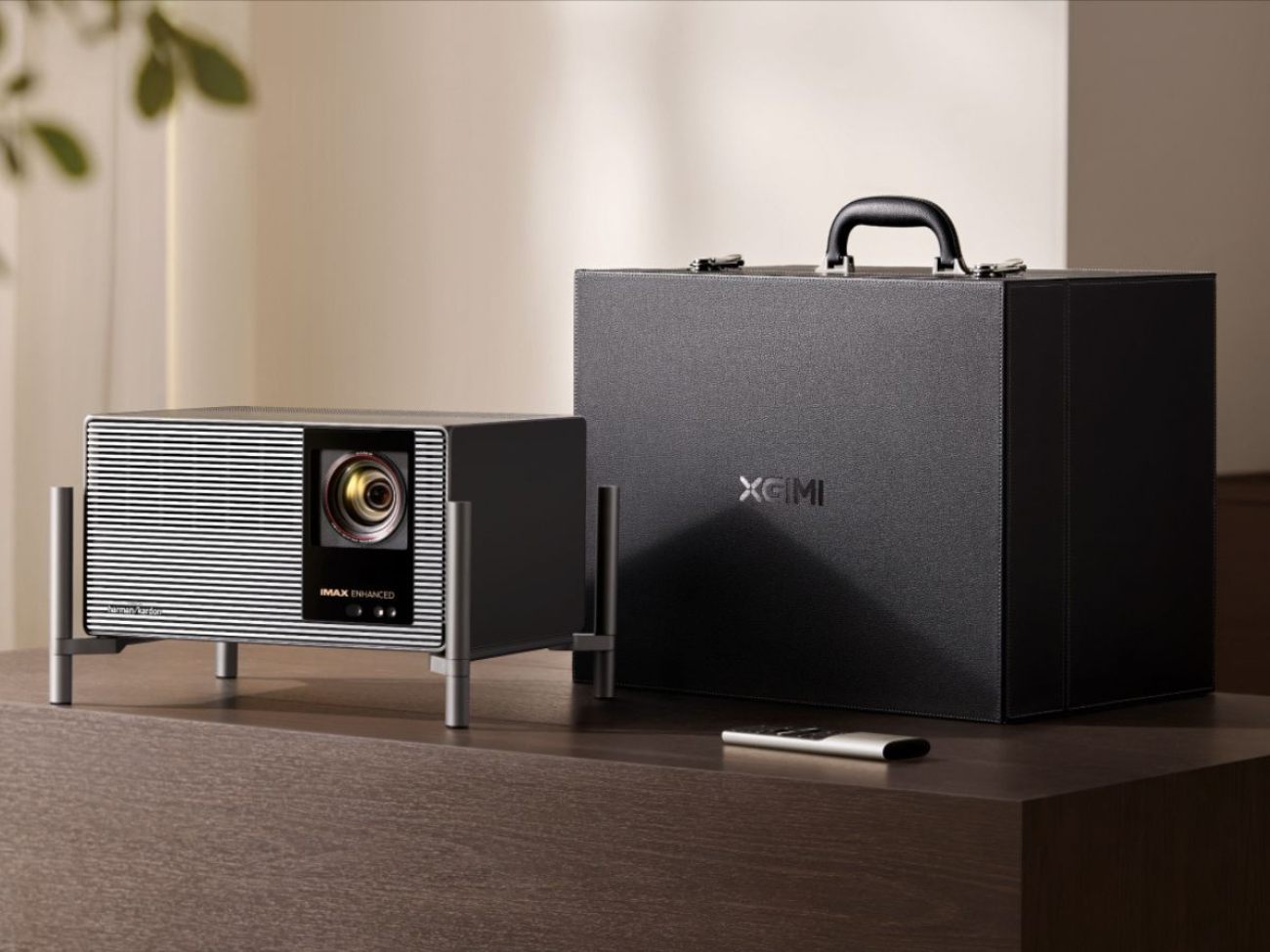 XGIMI X50 Ultra projecteur 4K laser au design rétro avec façade striée argentée, lentille X-Master 70mm, badge IMAX Enhanced et logo Harman Kardon, présenté à côté de sa mallette de transport en cuir noir et de sa télécommande argentée