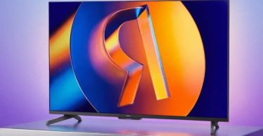 Téléviseur Yandex TV Station MiniLED affichant logo stylisé orange sur fond bleu-violet