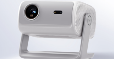 Vidéoprojecteur 4K Dangbei D7X Pro Super Bright Edition en finition blanche, vu de trois quarts sur son gimbal intégré orientable à 145 degrés, objectif triple laser RGB QuaLas 42 marqué 4K Ultra HD et grille de haut-parleur latérale