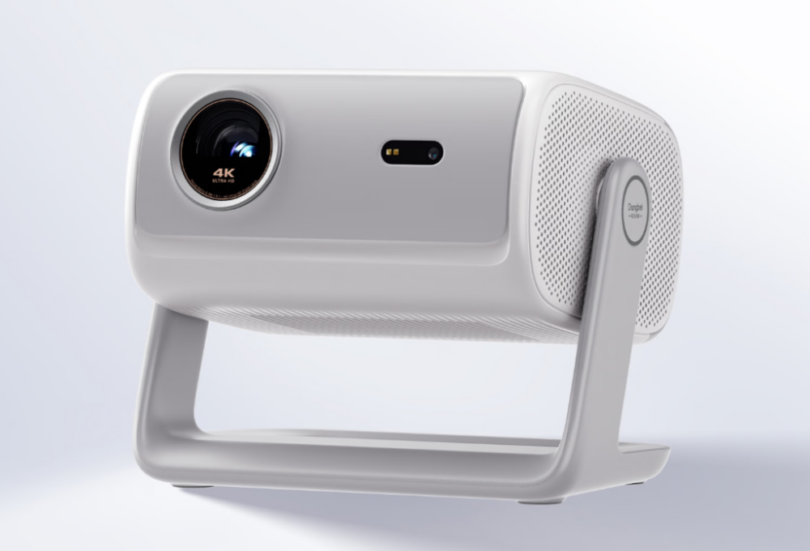 Vidéoprojecteur 4K Dangbei D7X Pro Super Bright Edition en finition blanche, vu de trois quarts sur son gimbal intégré orientable à 145 degrés, objectif triple laser RGB QuaLas 42 marqué 4K Ultra HD et grille de haut-parleur latérale