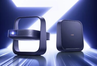Deux projecteurs portables XGIMI Z6X Pro 2026 bleu nuit, l'un vu de face objectif laser allumé dans son support carré intégré, l'autre de dos avec logo XGIMI, sur fond lumineux bleu